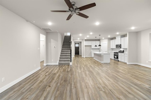 32307 Fly Fish Way, Fulshear, TX 77441 - unfurnished living room with a sink, a ceiling fan, baseboards, recessed lighting, and visible vents
