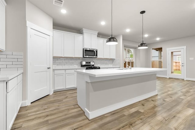 32307 Fly Fish Way, Fulshear, TX 77441 - kitchen featuring visible vents, tasteful backsplash, light wood-type flooring, a sink, and stainless steel appliances