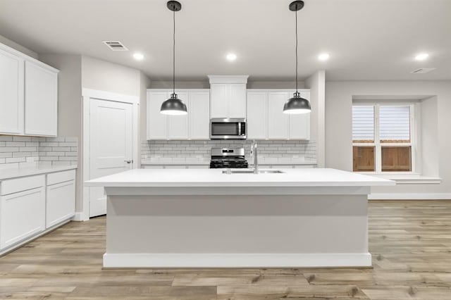 32307 Fly Fish Way, Fulshear, TX 77441 - kitchen featuring decorative backsplash, visible vents, a sink, light countertops, and stainless steel appliances
