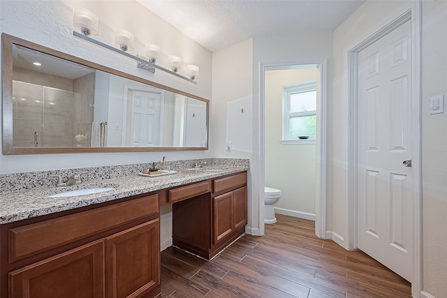 14811 El Miranda Dr, Houston, TX 77095 - full bathroom with double vanity, wood finished floors, toilet, a sink, and a stall shower