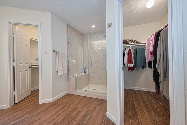 14811 El Miranda Dr, Houston, TX 77095 - bathroom featuring a textured ceiling, baseboards, a shower stall, and wood finished floors
