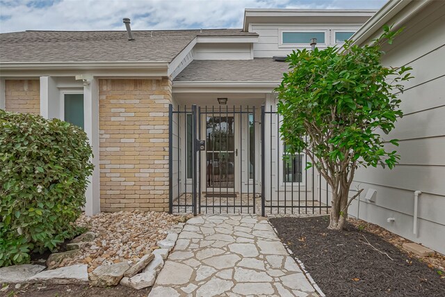 14811 El Miranda Dr, Houston, TX 77095 - view of exterior entry with a shingled roof and brick siding