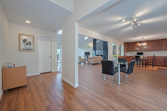 14811 El Miranda Dr, Houston, TX 77095 - living area featuring baseboards, light wood-type flooring, and a textured ceiling
