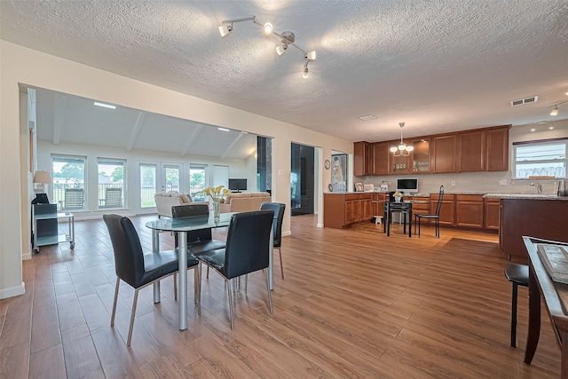 14811 El Miranda Dr, Houston, TX 77095 - dining room featuring light wood-style floors, a textured ceiling, a chandelier, vaulted ceiling with beams, and visible vents