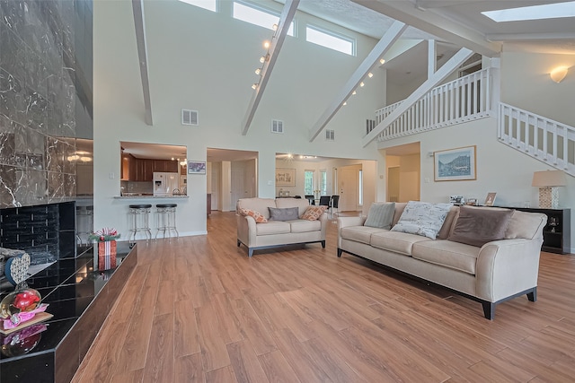 14811 El Miranda Dr, Houston, TX 77095 - living area with high vaulted ceiling, visible vents, a skylight, and wood finished floors