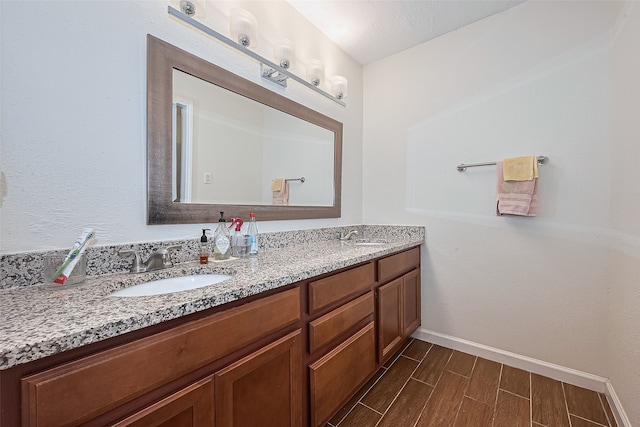 14811 El Miranda Dr, Houston, TX 77095 - bathroom featuring baseboards, a sink, wood finish floors, and double vanity