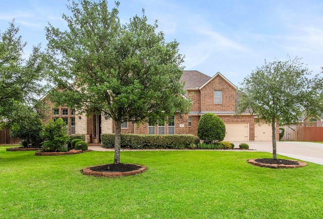 24818 Waterstone Estates Cir W, Tomball, TX 77375 - view of front facade with fence, a front yard, brick siding, concrete driveway, and an attached garage