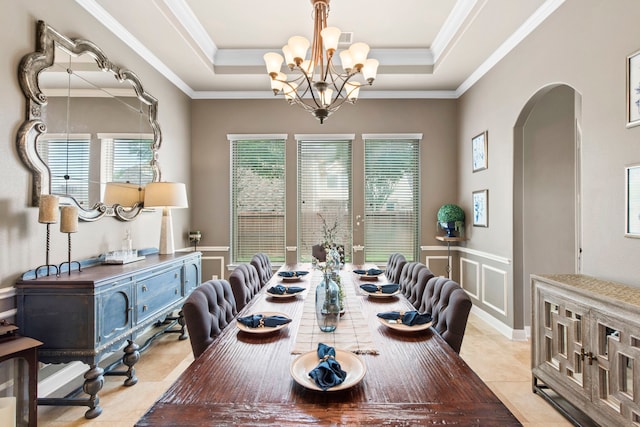 24818 Waterstone Estates Cir W, Tomball, TX 77375 - dining space featuring light tile patterned floors, arched walkways, a wainscoted wall, and a chandelier
