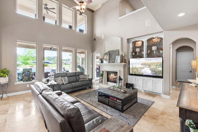 24818 Waterstone Estates Cir W, Tomball, TX 77375 - living area with arched walkways, ceiling fan, a high ceiling, and a healthy amount of sunlight