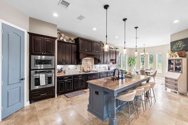 24818 Waterstone Estates Cir W, Tomball, TX 77375 - kitchen featuring a sink, stainless steel appliances, decorative backsplash, a kitchen bar, and visible vents