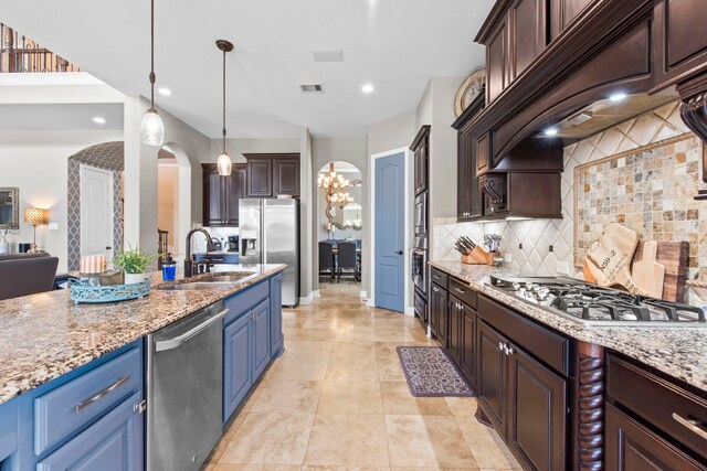 24818 Waterstone Estates Cir W, Tomball, TX 77375 - kitchen featuring decorative backsplash, appliances with stainless steel finishes, arched walkways, dark brown cabinets, and a sink
