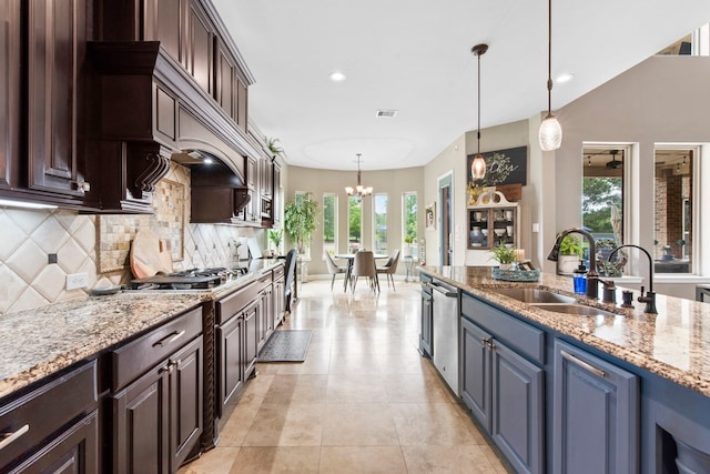 24818 Waterstone Estates Cir W, Tomball, TX 77375 - kitchen with dark brown cabinets, light stone countertops, an inviting chandelier, a sink, and backsplash