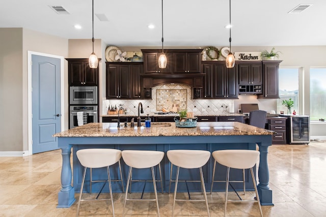 24818 Waterstone Estates Cir W, Tomball, TX 77375 - kitchen with a sink, appliances with stainless steel finishes, a kitchen breakfast bar, and beverage cooler
