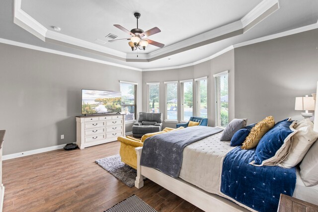 24818 Waterstone Estates Cir W, Tomball, TX 77375 - bedroom featuring visible vents, wood finished floors, a raised ceiling, baseboards, and ornamental molding