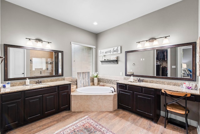 24818 Waterstone Estates Cir W, Tomball, TX 77375 - bathroom with wood finished floors, a bath, two vanities, a sink, and a tile shower