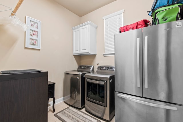 24818 Waterstone Estates Cir W, Tomball, TX 77375 - laundry room featuring baseboards, cabinet space, light tile patterned floors, and washing machine and clothes dryer