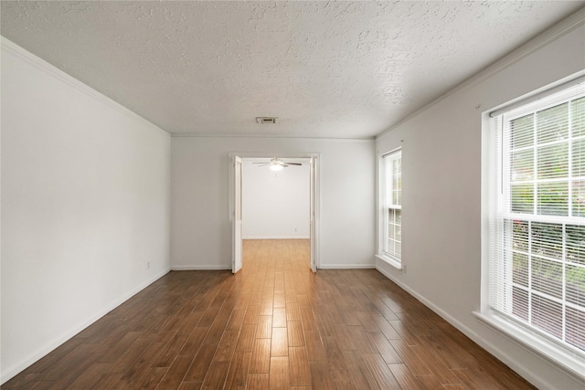 unfurnished room with visible vents, a textured ceiling, plenty of natural light, and wood finished floors
