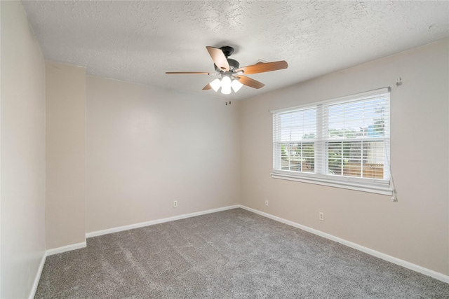 carpeted empty room featuring a textured ceiling, ceiling fan, and baseboards