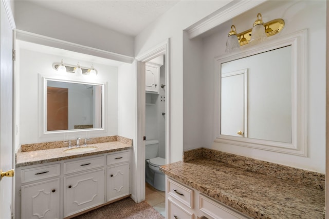 bathroom featuring vanity, tile patterned floors, and toilet