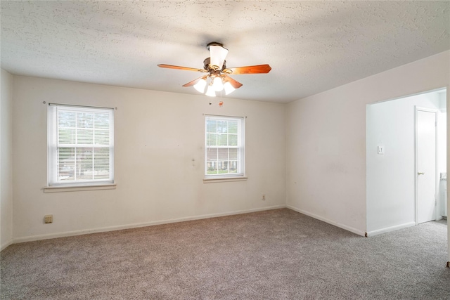 unfurnished room featuring carpet floors, ceiling fan, baseboards, and a textured ceiling