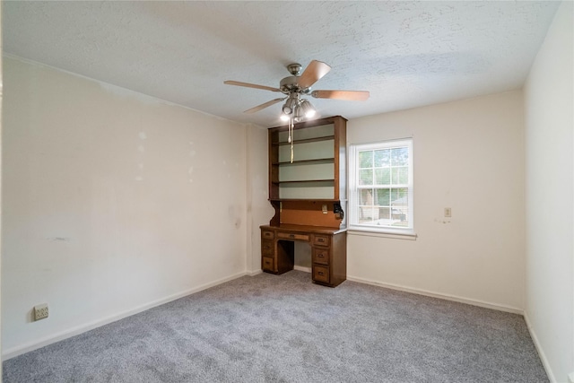 interior space featuring carpet floors, a ceiling fan, a textured ceiling, and baseboards