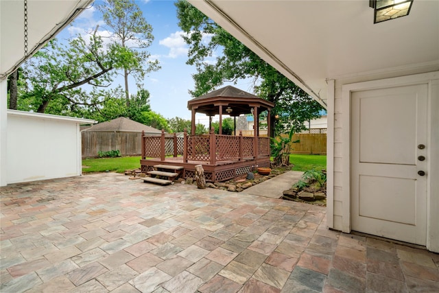 view of patio with a gazebo, a fenced backyard, and a wooden deck