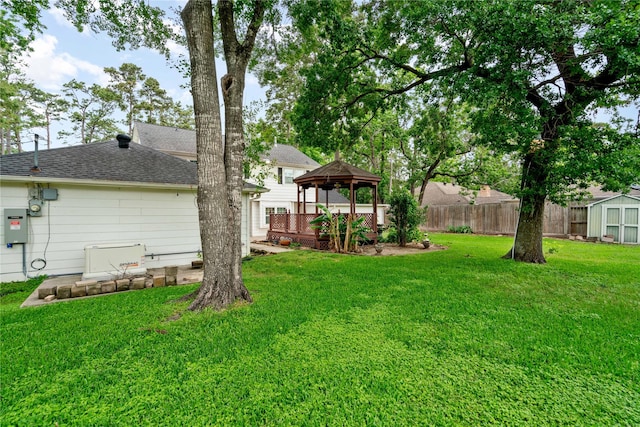 view of yard featuring a gazebo, an outdoor structure, fence, and a storage unit