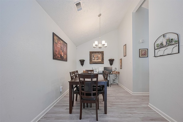 19944 Mountain Dale Dr, Cypress, TX 77433 - dining room with a chandelier, light wood-style flooring, baseboards, vaulted ceiling, and a textured ceiling