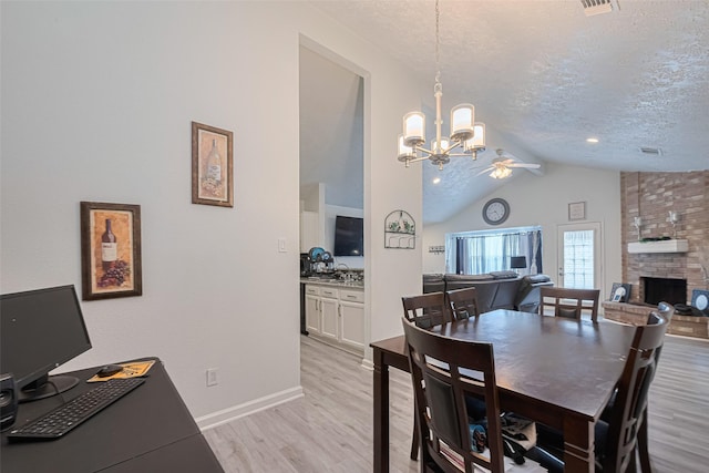 19944 Mountain Dale Dr, Cypress, TX 77433 - dining space with lofted ceiling, a chandelier, light wood finished floors, a textured ceiling, and a fireplace