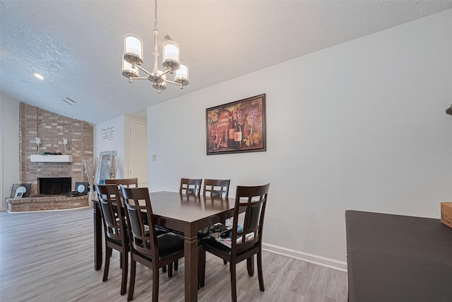 19944 Mountain Dale Dr, Cypress, TX 77433 - dining area with a chandelier, light wood-type flooring, lofted ceiling, a textured ceiling, and baseboards