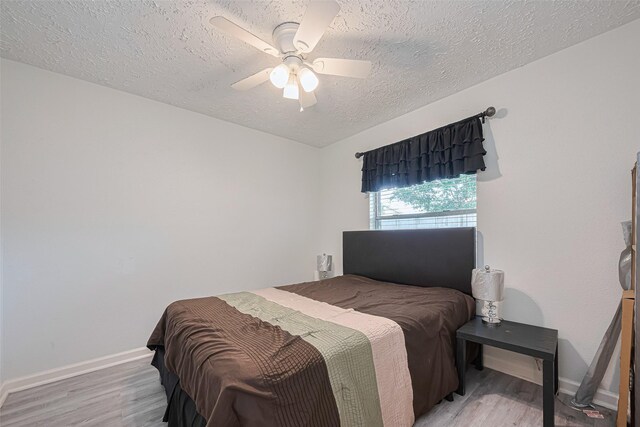 19944 Mountain Dale Dr, Cypress, TX 77433 - bedroom with a textured ceiling, light wood-style flooring, baseboards, and a ceiling fan