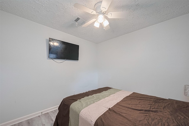 19944 Mountain Dale Dr, Cypress, TX 77433 - bedroom with wood finished floors, a textured ceiling, baseboards, and a ceiling fan