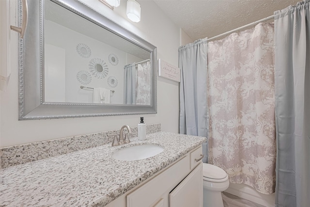 full bath featuring vanity, shower / bath combo, toilet, and a textured ceiling