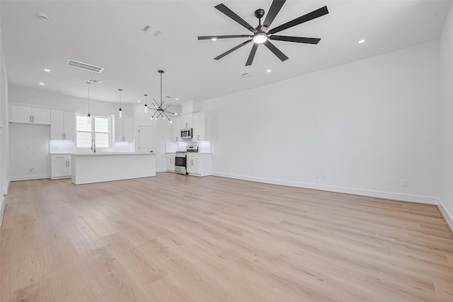 3114 Orange St, Houston, TX 77020 - unfurnished living room with a sink, ceiling fan with notable chandelier, light wood-style flooring, and visible vents