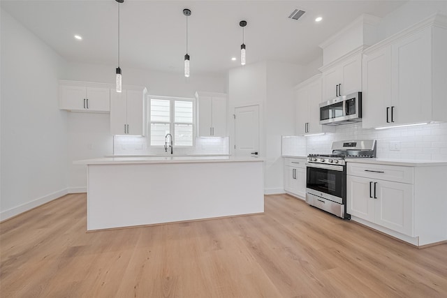 3114 Orange St, Houston, TX 77020 - kitchen with visible vents, decorative backsplash, light wood finished floors, and appliances with stainless steel finishes
