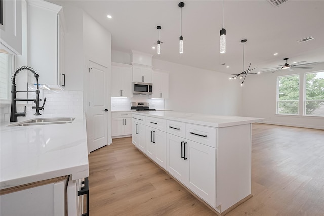 3114 Orange St, Houston, TX 77020 - kitchen with a sink, appliances with stainless steel finishes, backsplash, and light wood-type flooring
