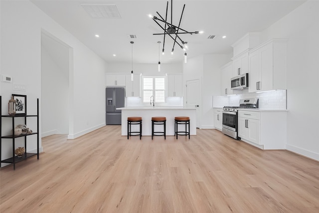 3114 Orange St, Houston, TX 77020 - kitchen featuring a kitchen island with sink, a kitchen bar, recessed lighting, backsplash, and stainless steel appliances