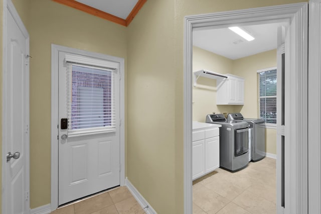13262 Royal Rdg, Conroe, TX 77302 - washroom featuring washing machine and clothes dryer, cabinet space, light tile patterned flooring, baseboards, and ornamental molding