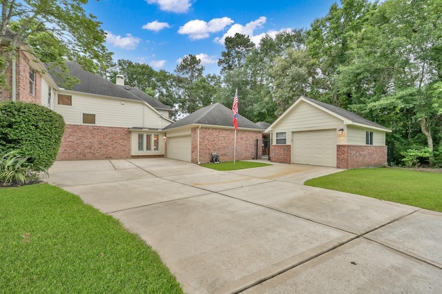 13262 Royal Rdg, Conroe, TX 77302 - view of front of house featuring brick siding, a front yard, driveway, an outdoor structure, and a garage