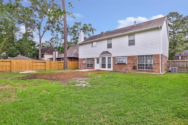 4523 Natural Bridge Dr, Kingwood, TX 77345 - back of house with brick siding, a chimney, and cooling unit