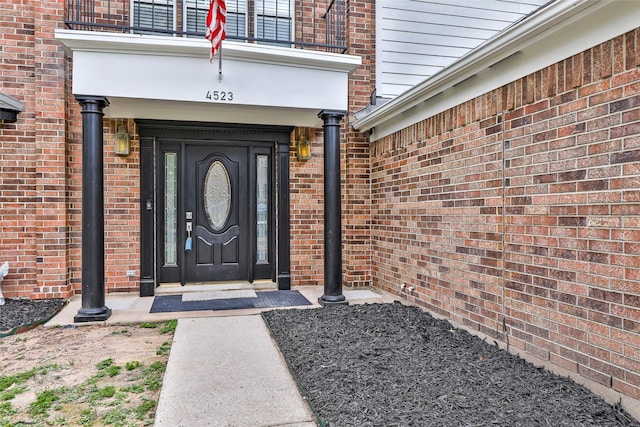 4523 Natural Bridge Dr, Kingwood, TX 77345 - view of exterior entry featuring brick siding and a balcony