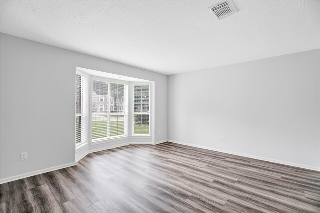 4523 Natural Bridge Dr, Kingwood, TX 77345 - spare room with wood finished floors, baseboards, and a textured ceiling