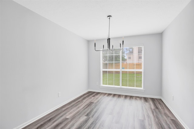 4523 Natural Bridge Dr, Kingwood, TX 77345 - unfurnished dining area featuring a chandelier, wood finished floors, and baseboards
