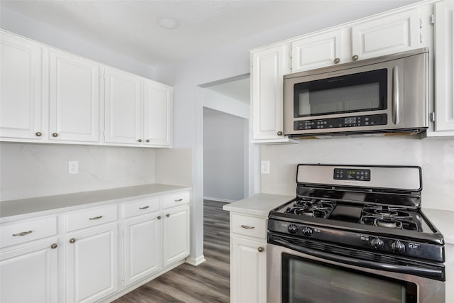 4523 Natural Bridge Dr, Kingwood, TX 77345 - kitchen featuring stainless steel appliances, light countertops, wood finished floors, and white cabinetry