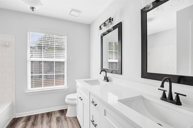 4523 Natural Bridge Dr, Kingwood, TX 77345 - bathroom featuring healthy amount of natural light, double vanity, toilet, and wood finished floors