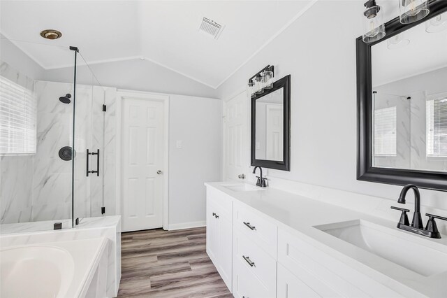 4523 Natural Bridge Dr, Kingwood, TX 77345 - full bathroom featuring a marble finish shower, double vanity, a bath, wood finished floors, and lofted ceiling