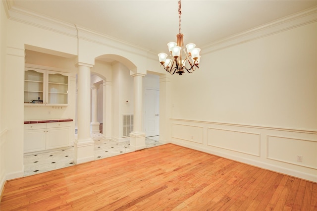 16 Treverstone Ct, Sugar Land, TX 77479 - unfurnished dining area with an inviting chandelier, light wood finished floors, arched walkways, visible vents, and ornamental molding