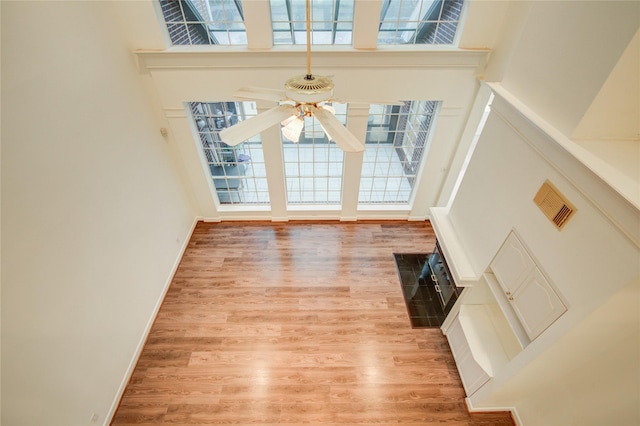 16 Treverstone Ct, Sugar Land, TX 77479 - unfurnished living room with ceiling fan, a high ceiling, baseboards, wood finished floors, and visible vents