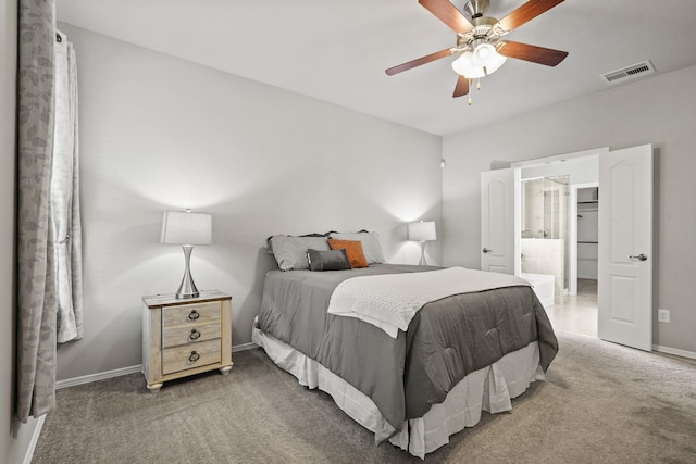 carpeted bedroom with a ceiling fan, baseboards, visible vents, and ensuite bath