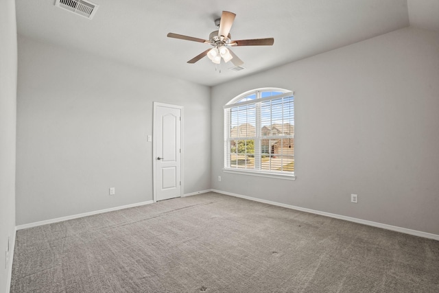 carpeted spare room featuring visible vents, a ceiling fan, and baseboards